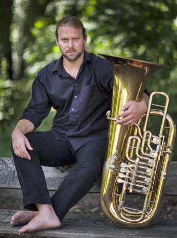 Andreas Martin Hofmeir sitzend mit seiner Tuba im Arm